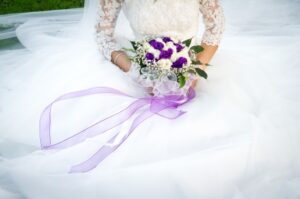 Photo of a women kneeling in a wedding dress. 